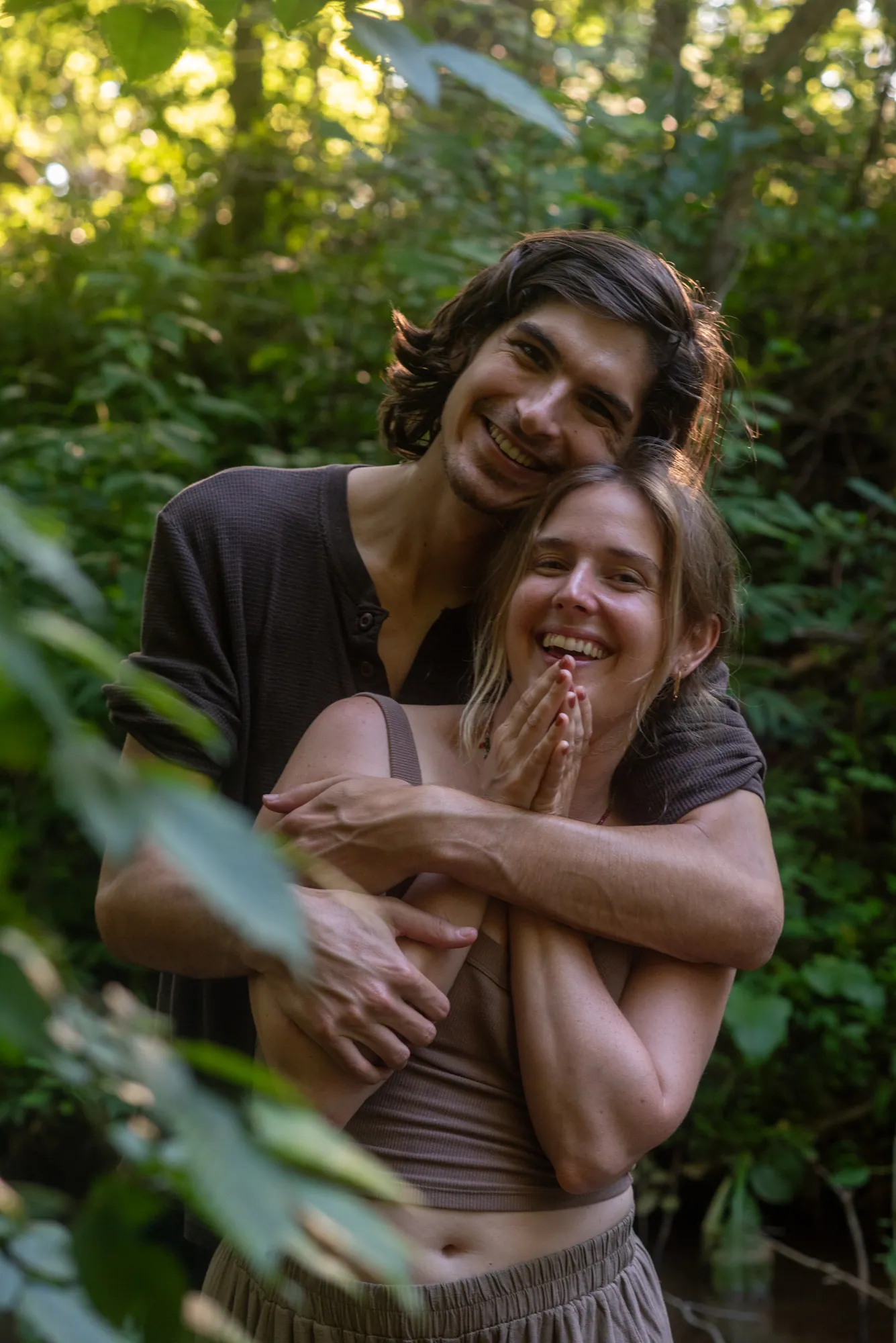 A couple in golden backlight beside an Asheville creek
