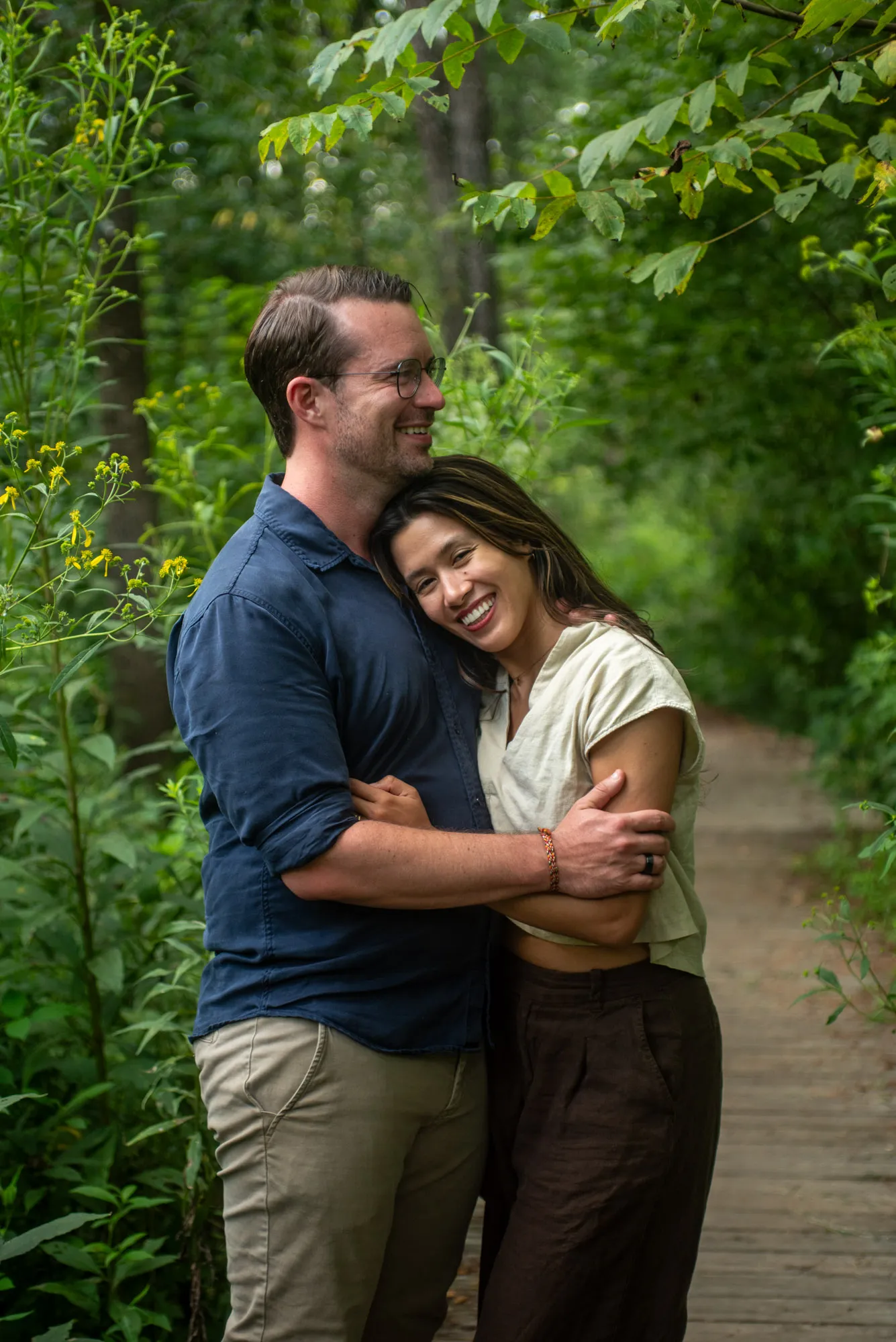 A couple laughing together on a garden boardwalk in Asheville